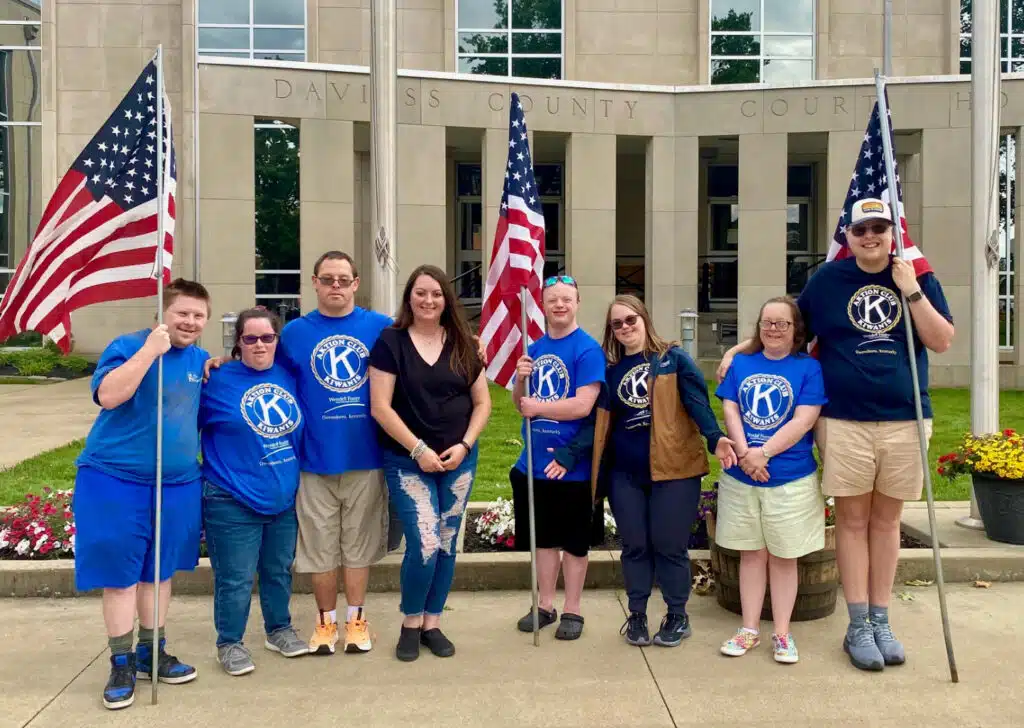 Members of Aktion Club smiling and holding flags