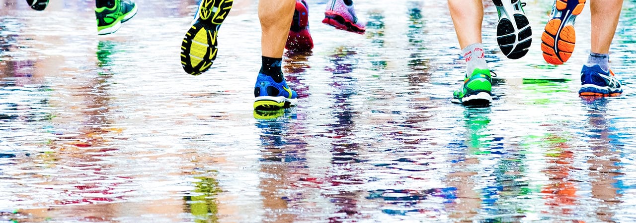 people running in a marathon on a wetted surface