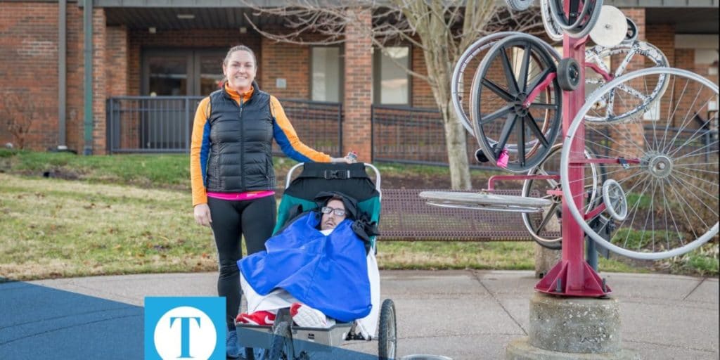 Runner standing next to person in jogging stroller